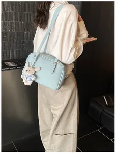 Detail of light blue lychee pattern crossbody bag with a cute white rabbit pendant charm