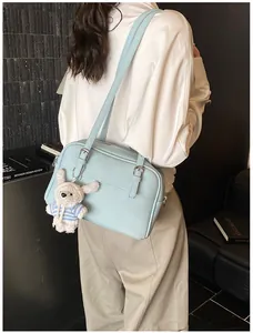 Detail of light blue lychee pattern shoulder bag with a cute white rabbit charm