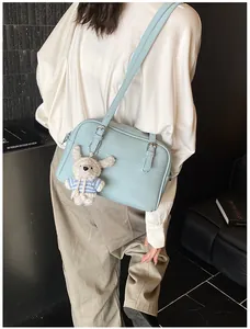Detail of light blue lychee pattern shoulder bag with cute rabbit plush keychain charm