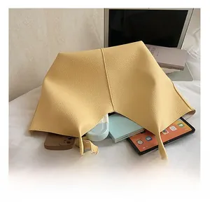 Internal capacity of yellow pebble leather tote bag showing space for tablet and books
