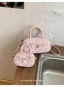 Detailed set of floral pink handbags with bow charms on a wooden surface