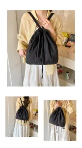 Detail showing the adjustable drawstring closure and nylon fabric of this black backpack