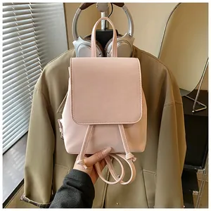 Close-up of pink faux leather mini backpack with drawstring and flap closure details