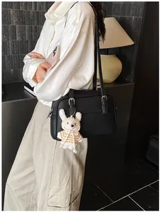 Detail of black lychee grain texture small square bag with cute white rabbit pendant