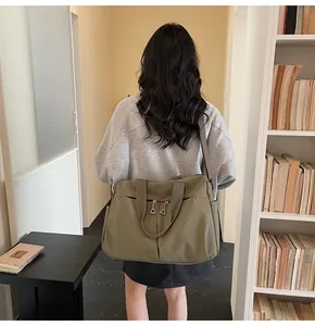 Dettaglio borsa da viaggio in tela verde militare con tasche frontali e trama resistente