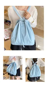 Close-up of light blue drawstring backpack showing shoulder straps and canvas texture