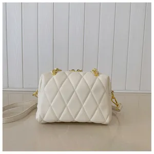 Dettaglio ravvicinato della pelle trapuntata beige e finiture in metallo dorato lucido