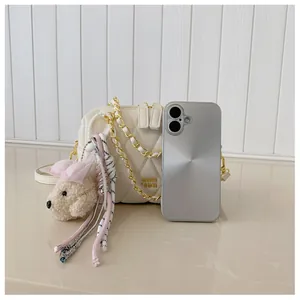 Borsa a tracolla beige trapuntata con catena dorata e ciondolo a forma di cucciolo
