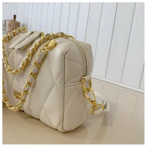 Dettaglio borsa trapuntata beige in pelle con finiture dorate e tracolla a catena