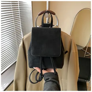Detail of minimalist black matte backpack with drawstring closure and vintage flap design