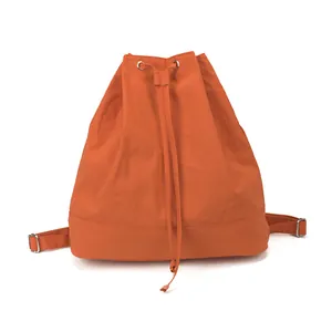 Detail of orange drawstring backpack showing metal eyelets and reinforced bottom stitching