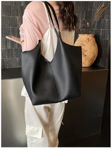 Detail of black pebbled leather tote bag showing large capacity and premium texture