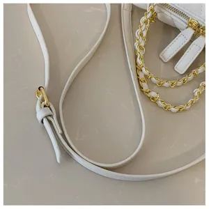 Dettaglio della borsa trapuntata bianca con catena intrecciata dorata e tracolla regolabile