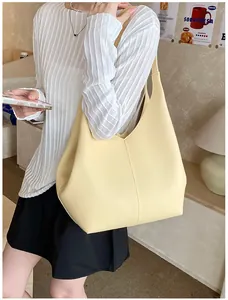 Detail of cream yellow leather tote bag with vertical stitching and textured finish