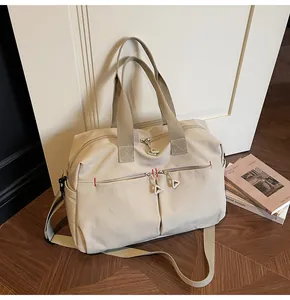 Dettaglio borsa da viaggio in tela con cuciture rosse e tasche con zip verticali
