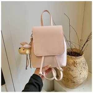 Detail of soft pink backpack with drawstring closure and cute plush bear charm