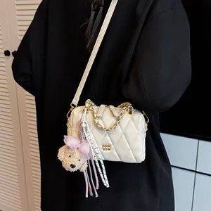 Borsa a tracolla trapuntata color crema con catena dorata e ciondolo a cucciolo