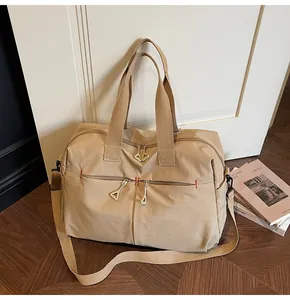 Dettaglio borsa da viaggio in tela kaki con tracolla regolabile e cerniere metalliche