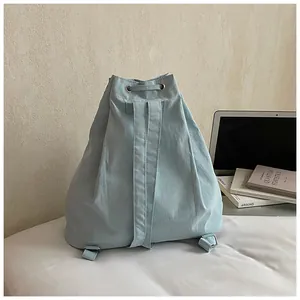 Detail of mint green drawstring backpack with adjustable straps and metal eyelets
