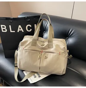 Dettaglio borsa da viaggio in tela con cuciture rosse e tracolla resistente