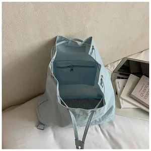 Detail view of light blue backpack interior with zipper pocket and striped lining