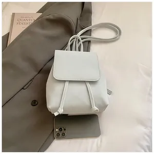 Detail of light blue mini faux leather backpack with drawstring and magnetic flap closure