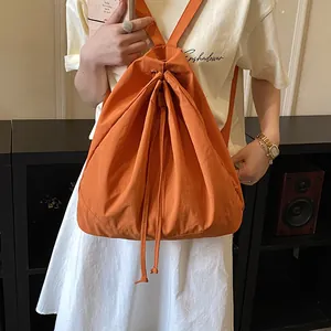 Detailed view of the vibrant orange drawstring backpack in a stylish indoor setting