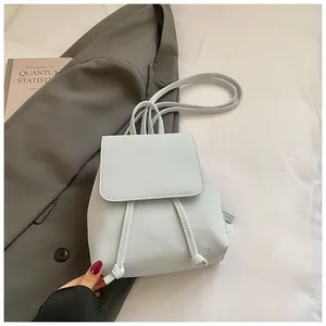 Detail view of mini light blue faux leather backpack with drawstring and flap closure