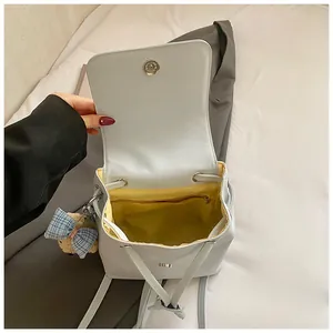 Detail view of large capacity backpack interior with yellow lining and plush bear charm