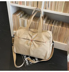 Dettaglio borsa da viaggio in tela kaki con tasche a zip e tracolla ampia regolabile