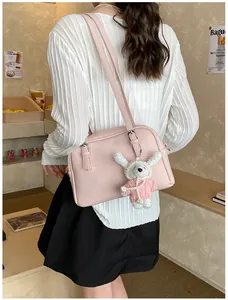 Pink lychee texture crossbody bag with cute bear charm shown in a daily casual setting