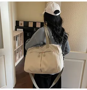 Dettaglio della borsa da viaggio in tela con cuciture rosse e doppie tasche frontali