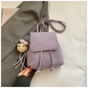 Detail view of lavender PU leather backpack with drawstring closure and plush bear charm
