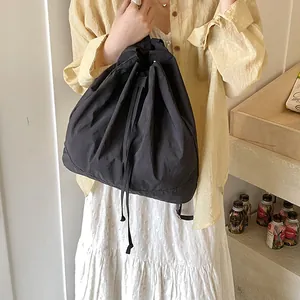 Detailed view of black nylon drawstring bag showing textured fabric and casual style