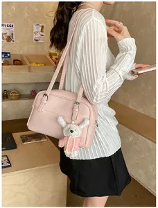 Close-up of pink litchi grain shoulder bag featuring a cute white bear charm detail