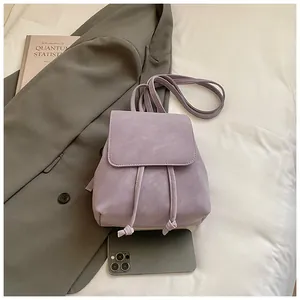 Top view of a lilac leather backpack with drawstring closure and fashion props