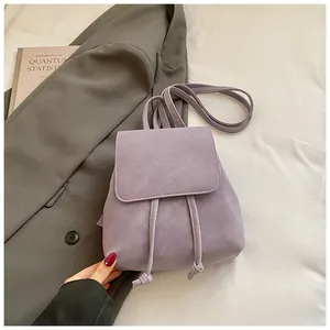 Detail of light purple faux leather backpack with drawstring closure and vintage texture