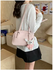 Detail view of pink lychee pattern texture and white rabbit plush pendant on tote bag