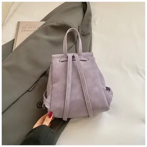 Detail of light purple drawstring backpack with matte leather texture and slim straps