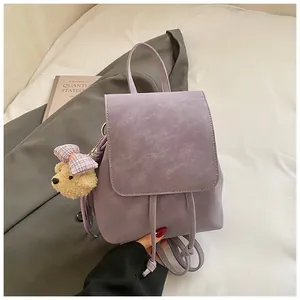 Detailed close-up of a purple textured PU leather backpack with a cute bear charm
