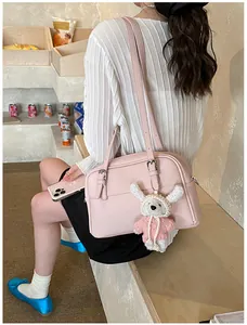 Pink litchi texture crossbody bag detail with silver buckle and cute plush bear charm