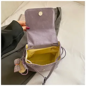 Detail view of purple backpack with yellow lining, interior zipper pocket and drawstring