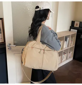 Dettaglio borsa da viaggio in tela kaki con doppie tasche a zip e tracolla larga