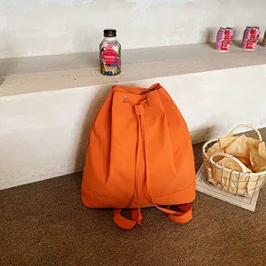 Vibrant orange drawstring backpack made of durable canvas for versatile outdoor sports use