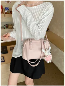 Detailed shot of pink lychee pattern crossbody bag with a cute plush rabbit charm