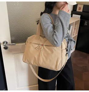 Dettaglio della borsa da viaggio in tela kaki con tasca a zip e tracolla regolabile
