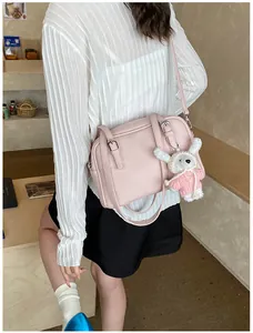 Detail of pink lychee texture crossbody bag with adjustable strap and cute bunny charm