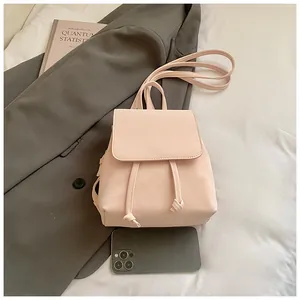 Mini pink PU leather backpack detail with drawstring closure and phone for scale