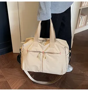 Dettaglio della borsa da viaggio in tela con manici rinforzati e tracolla regolabile