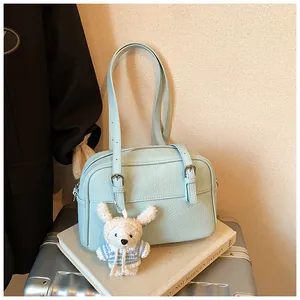 Close-up of light blue lychee pattern shoulder bag with a cute white bunny pendant